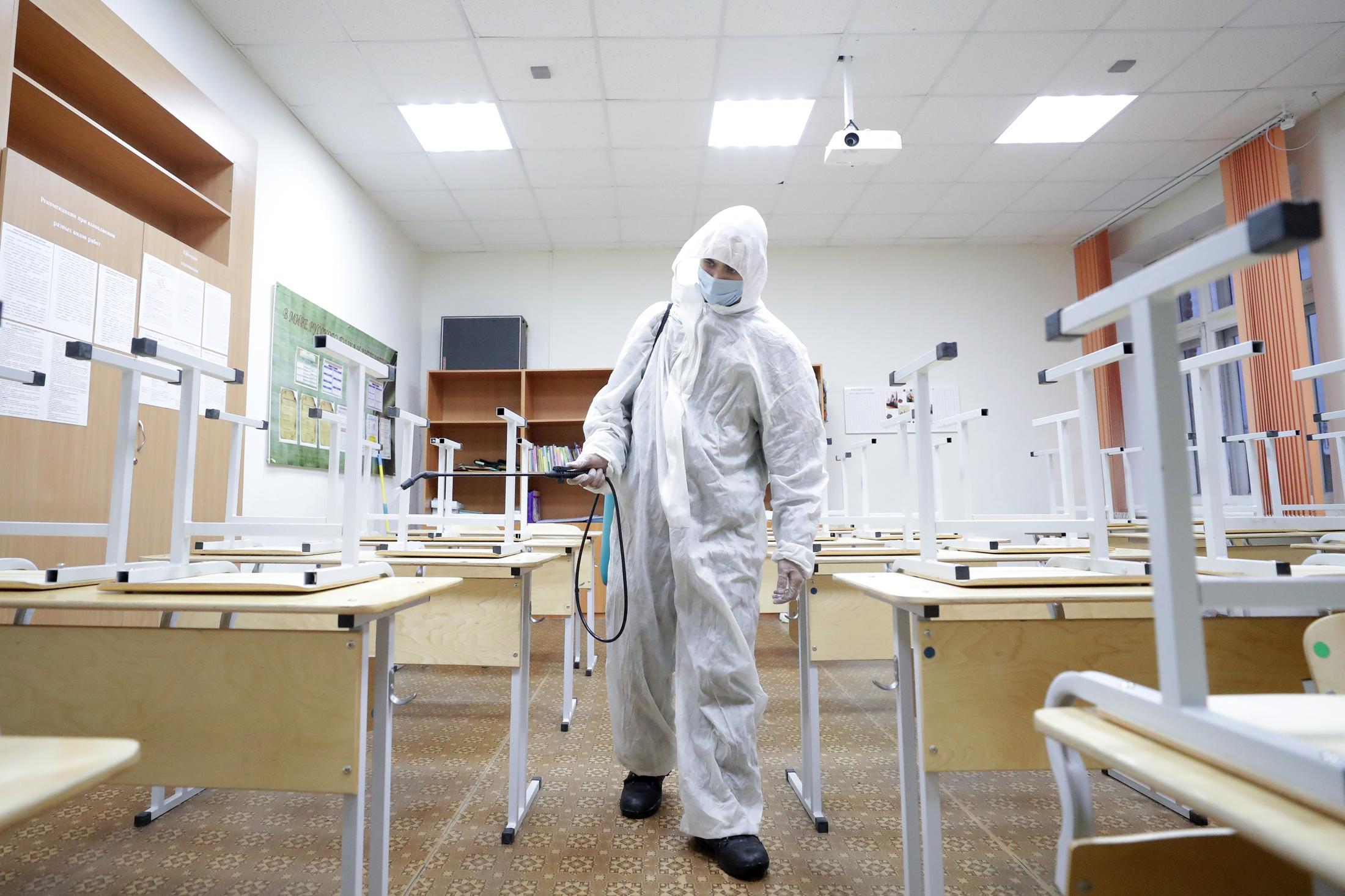 Проводит дезинфекцию в школьном классе